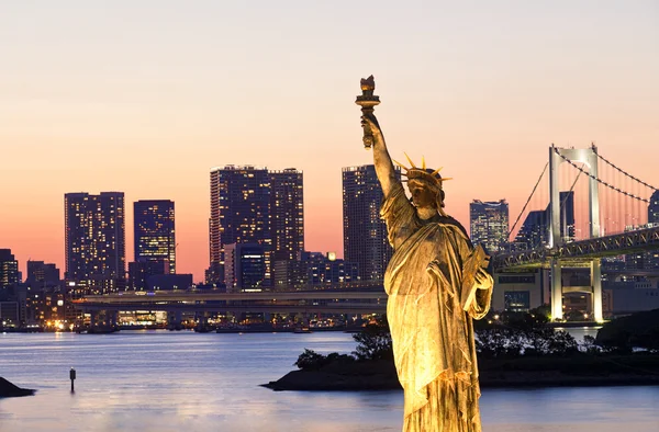 Tokyo skyline, statue of Liberty and Rainbow Bridge with cityscape at Odaiba island,Japan