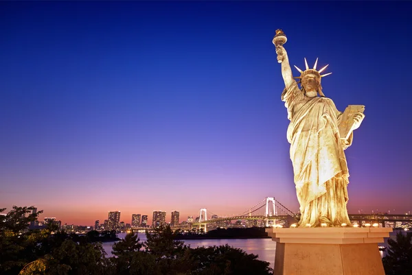 Statue of Liberty and Rainbow Bridge with cityscape at Odaiba island,Tokyo