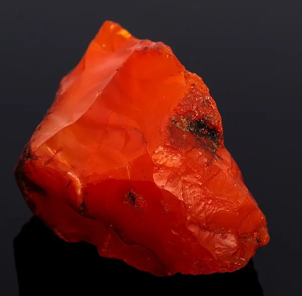 Rough red carnelian rock isolated on black background