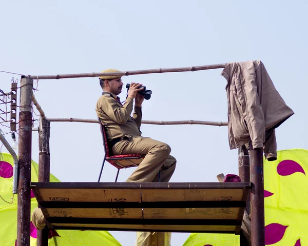 Policman on watchtower looking in field glass