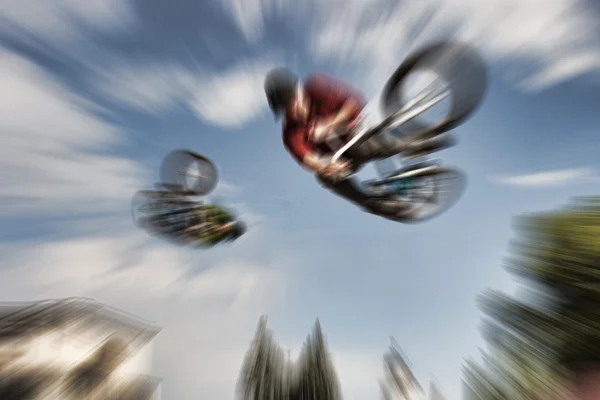 Abstract background . Two BMX bikers high up in the air. Some mo
