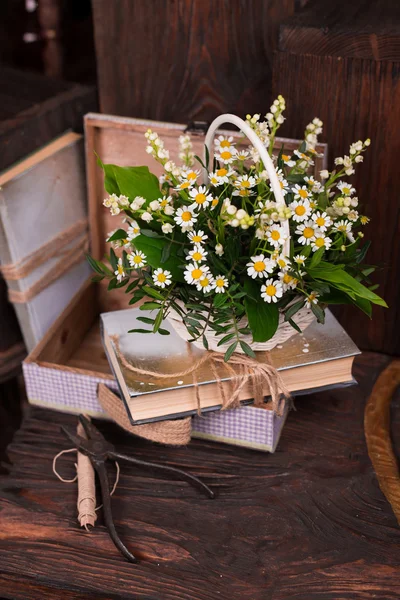 Chamomile decor composition with books and box on the brown wood table
