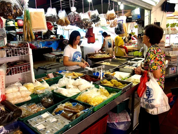 A woman chooses from a wide variety of fresh food from a market in the town of Tampines in Singapore