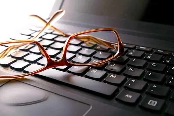 Pair of eyeglasses on a computer keyboard