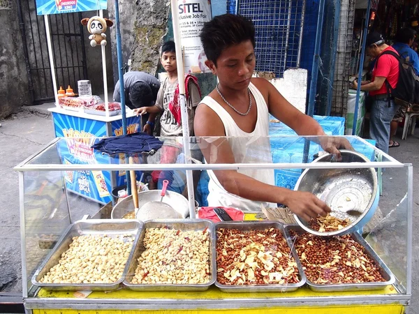 A food vendor beside the famous Antipolo Church sells cooked peanuts.
