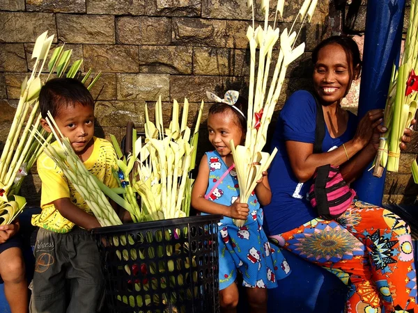 Vendors prepare palm leaves to be sold to church patrons