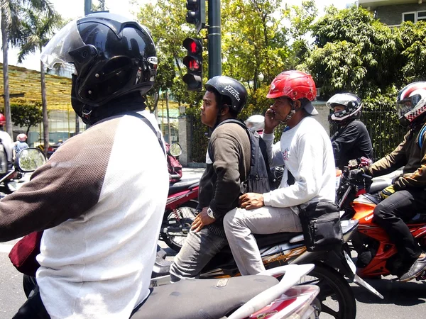 Motorcycle riders wait for the light to turn green at an intersection