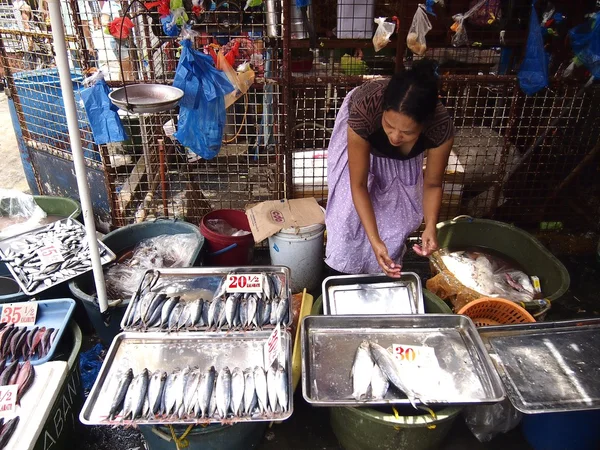 Vendors inside a public market sell a wide variety of fresh fish and other sea foods .