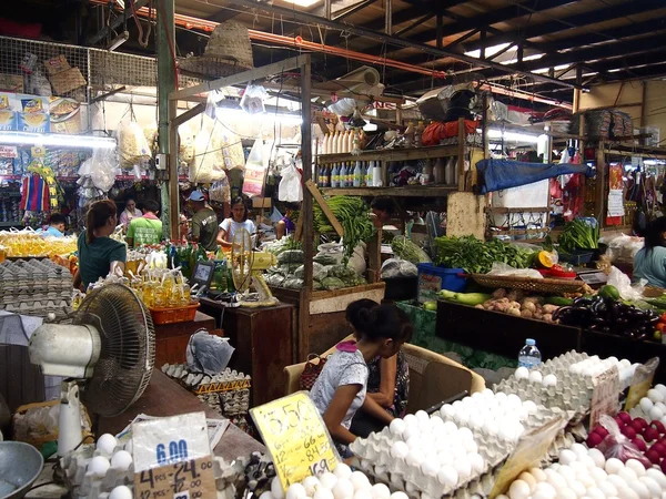Vendors inside a public market sell a wide variety of fresh and raw food