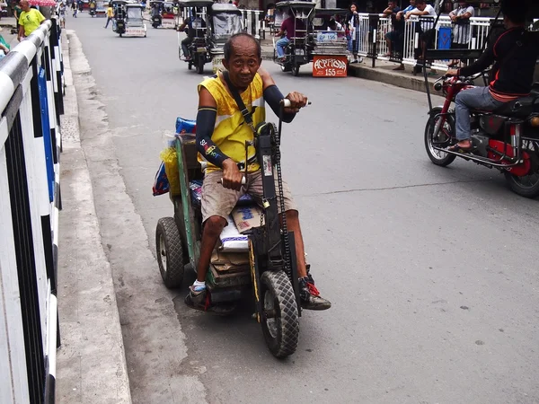 A person with disability rides and maneuvers an improvised wheel chair