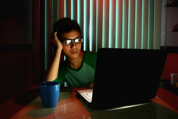 Young Teen with eyeglasses in front of a laptop computer