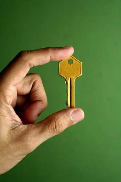 Golden key held in hand