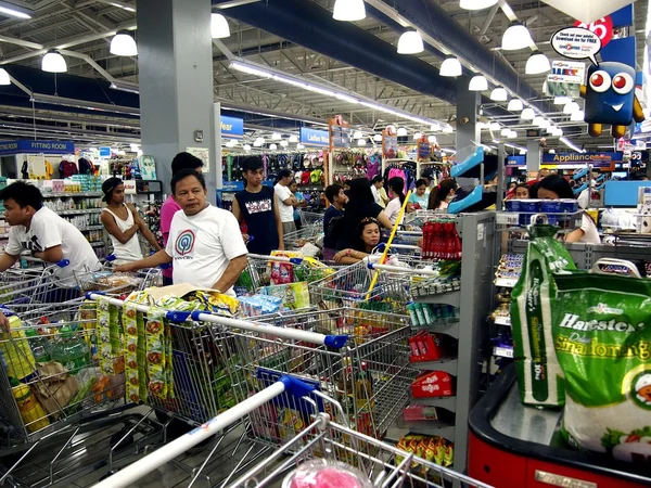 Customers line up with their shopping cart