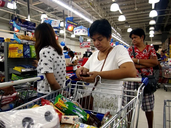 Customers line up with their shopping cart