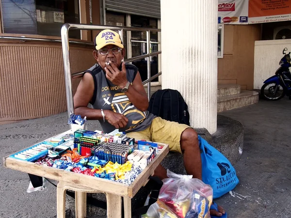 A man sells candies, cigarettes and lighters