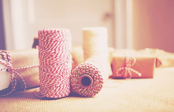 Spools of yarn on a desk with gift boxes