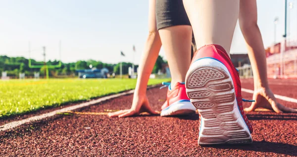 Female athlete on the starting line of a stadium track