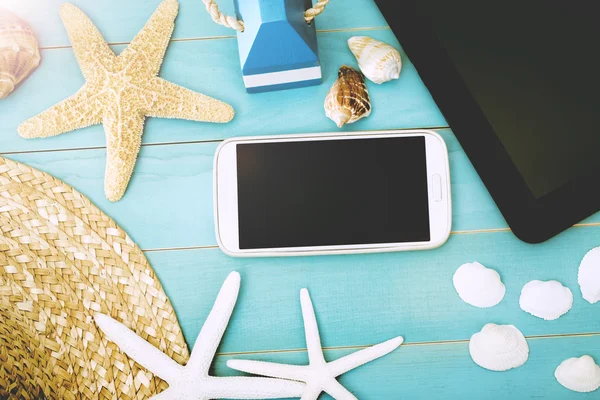 Gadgets on the Table with Starfish, Shells and Hat