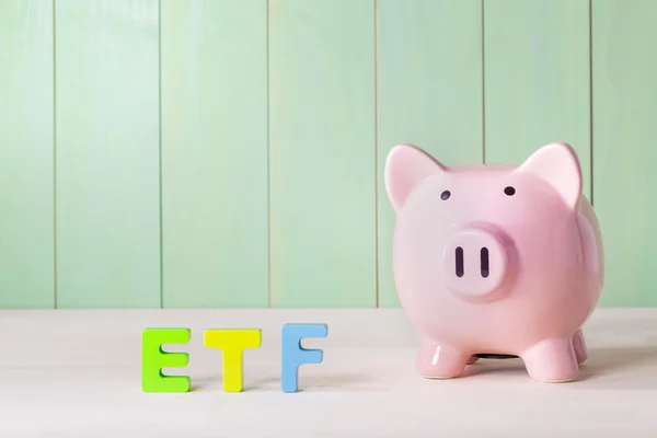 Exchange Traded Funds theme with letters and piggy bank