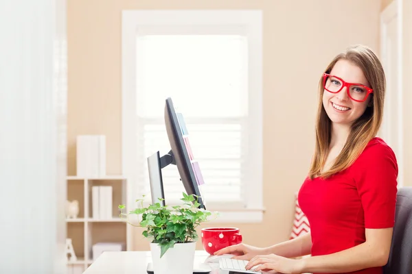 Happy young woman working in her home office