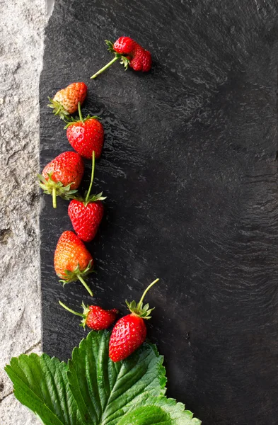 Menu concept with slate background and strawberries
