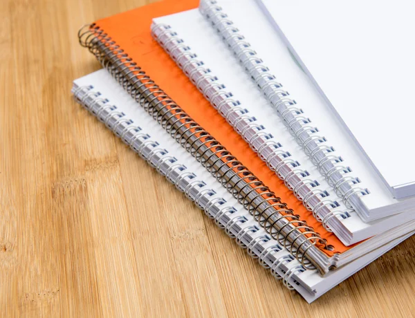 Stack of white and orange Personal office notebooks