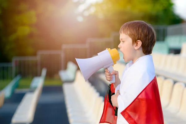 Polish football fan - little boy with megaphone and Polish flag supporting national team