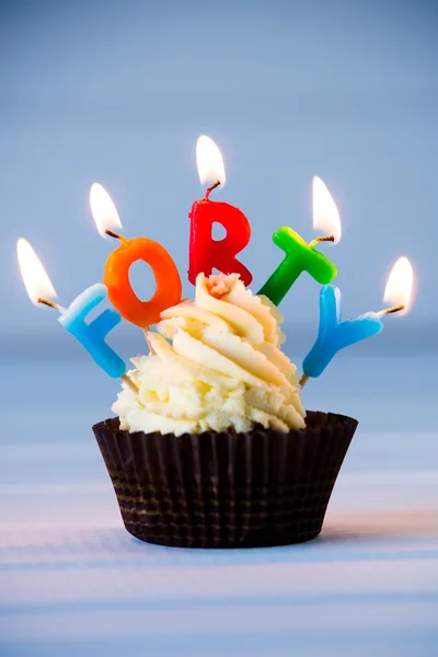 Cupcake with a candles for 40 - fortieth birthday . Happy birthday !