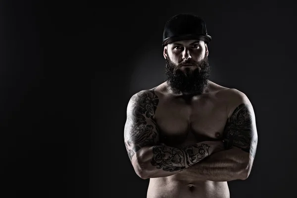 Studio shot of Muscular  Man with tattoo on dark background