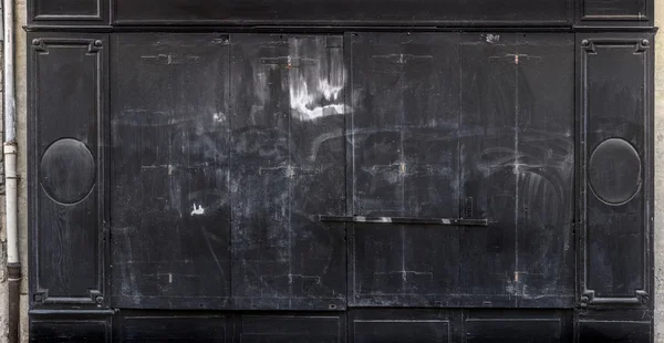 Antique black wooden doors of a store.