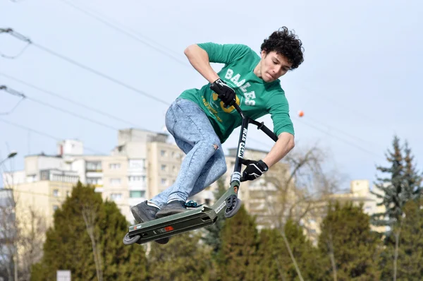 Young guy doing a jump with his scooter