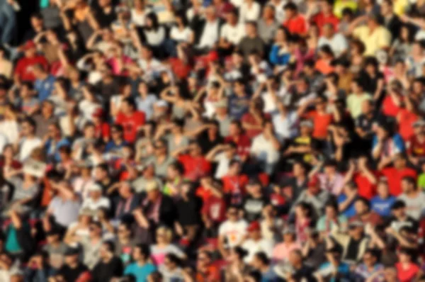 Crowd in a stadium. Blurred heads and faces of spectators