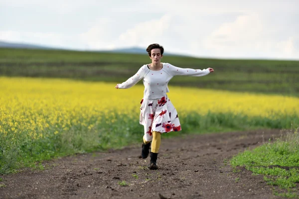 Young woman running on a countryside road. Freedom concept