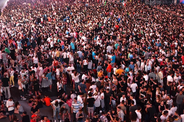 Large crowd of people at a concert in the front of the stage