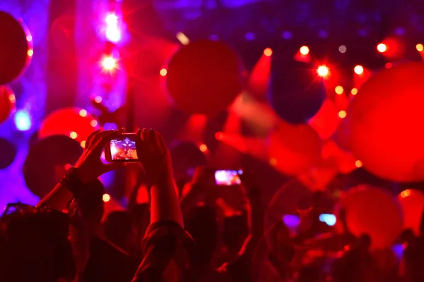 Silhouette of people taking photos with smart phones at live con