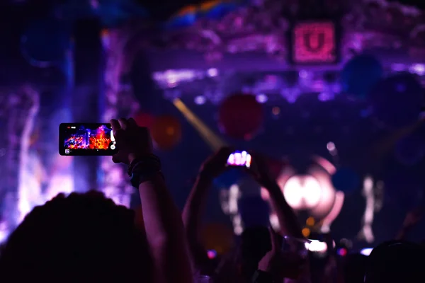 Silhouette of people taking photos with smart phones at live con