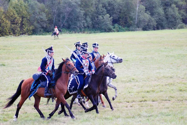 Reenactors dressed as Napoleonic war soldiers ride horses