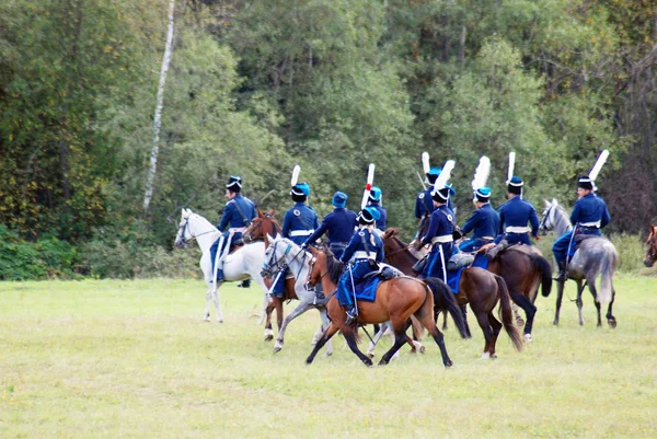 Reenactors dressed as Napoleonic war soldiers ride horses