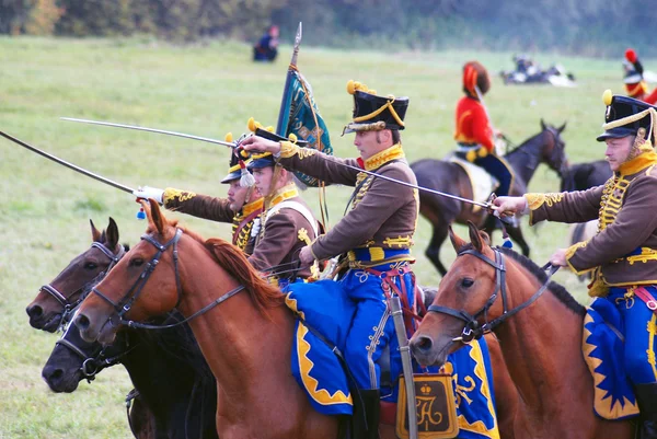 Reenactors dressed as Napoleonic war soldiers ride horses