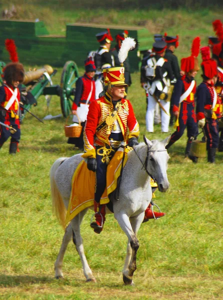 Reenactor dressed as Napoleonic war soldier rides a horse.