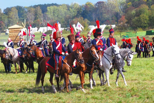 Reenactors dressed as Napoleonic war soldiers ride horses