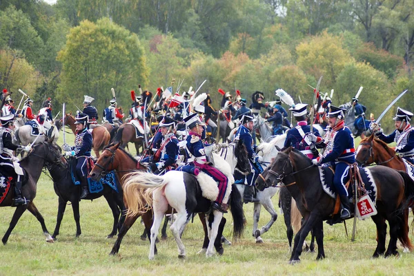 Reenactors dressed as Napoleonic war soldiers ride horses