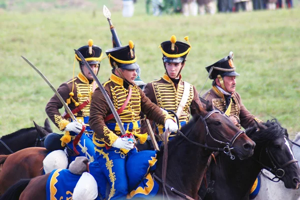 Reenactors dressed as Napoleonic war soldiers ride horses