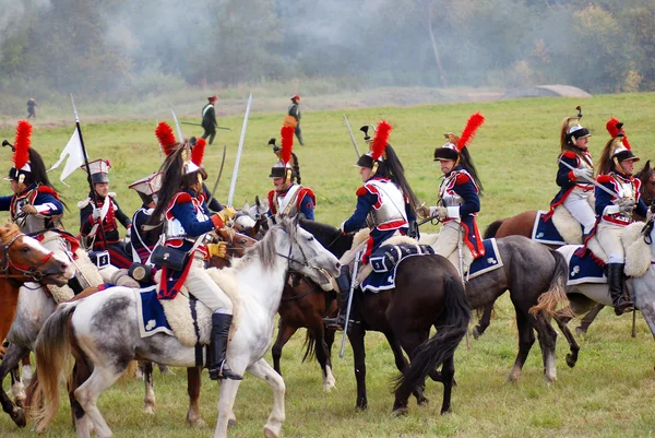 Reenactors dressed as Napoleonic war soldiers ride horses