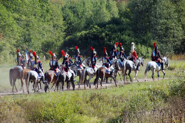 Reenactors dressed as Napoleonic war soldiers ride horses