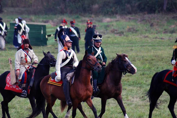 Reenactors dressed as Napoleonic war soldiers ride horses