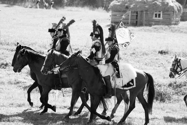 Reenactors dressed as Napoleonic war soldiers ride horses