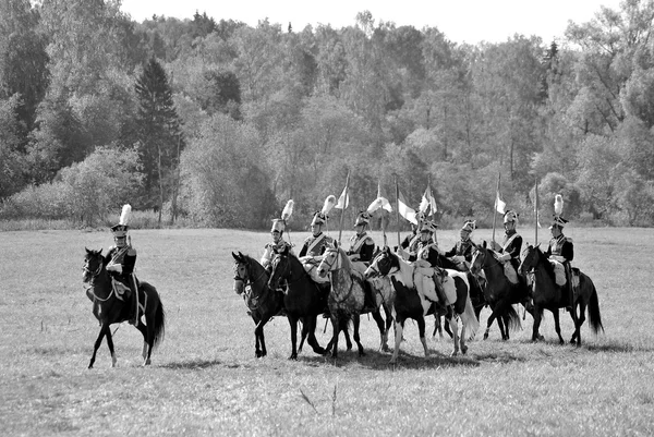 Reenactors dressed as Napoleonic war soldiers ride horses