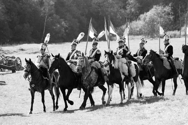 Reenactors dressed as Napoleonic war soldiers ride horses