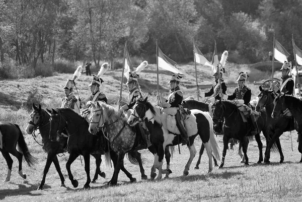 Reenactors dressed as Napoleonic war soldiers ride horses